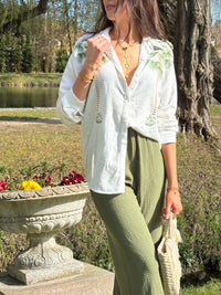 La chemise Paloma en motifs palmiers est une pièce légère et confortable pour femmes. Avec ses manches longues et son col chemise, elle offre un style élégant. Les boutons sur la longueur et aux manches ajoutent une touche de praticité. Cette chemise vous transportera vers un paradis tropical.