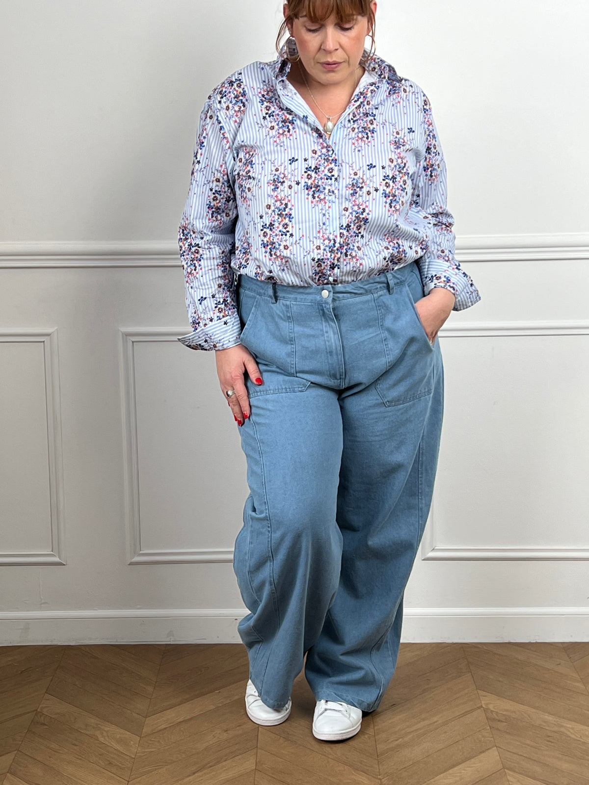 Laissez-vous séduire par cette chemise fleurie grande taille femme, élégante et pleine de fraîcheur. Dotée de manches longues avec boutons aux poignets et d’une fermeture boutonnée sur toute la longueur, elle présente un col chemise classique. Ses rayures verticales bleues et écrues sont sublimées par de motifs fleurs colorées, pour un look à la fois féminin et lumineux.