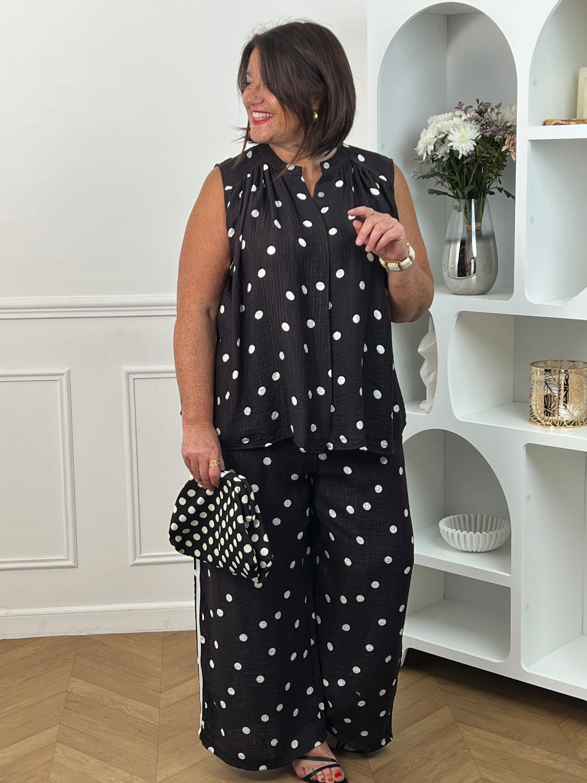 Craquez pour cette chemise à motifs grande taille femme, idéale pour un look à la fois chic et décontracté. Sans manches et dotée d’un col rond, elle séduit par ses élégants motifs pois noir et écru qui apportent une touche intemporelle à votre tenue. Les boutons sur toute la longueur soulignent son style raffiné, tandis que sa matière légèrement transparente lui confère légèreté et féminité. Une pièce tendance et confortable, parfaite pour la saison.