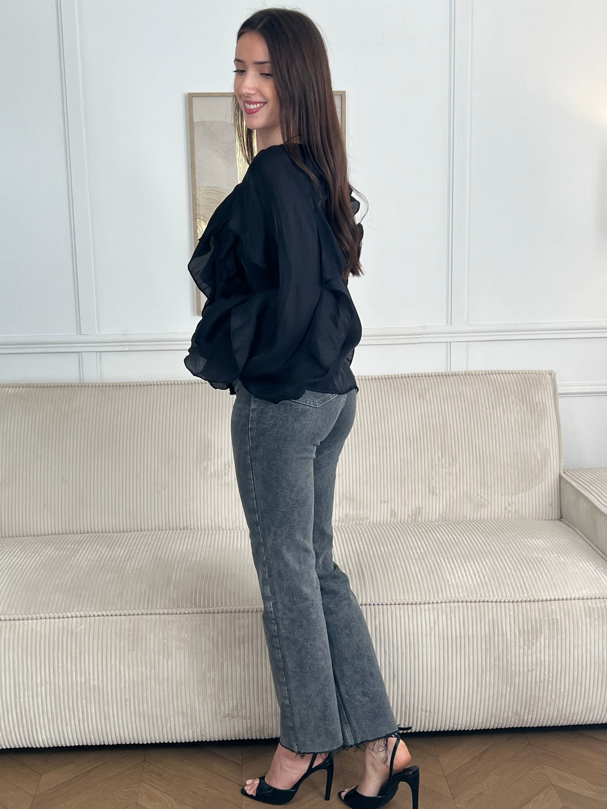 Légère et pleine de charme, cette chemise noire pour femme apporte une touche lumineuse et féminine à votre tenue. Son col V délicatement souligné par un élastique met en valeur le décolleté, tandis que les poignets élastiqués assurent un joli tombé aux manches longues. Les volants au col, aux épaules et aux manches ajoutent du mouvement et une note romantique à l’ensemble. Sa matière légèrement transparente renforce son côté aérien et élégant.