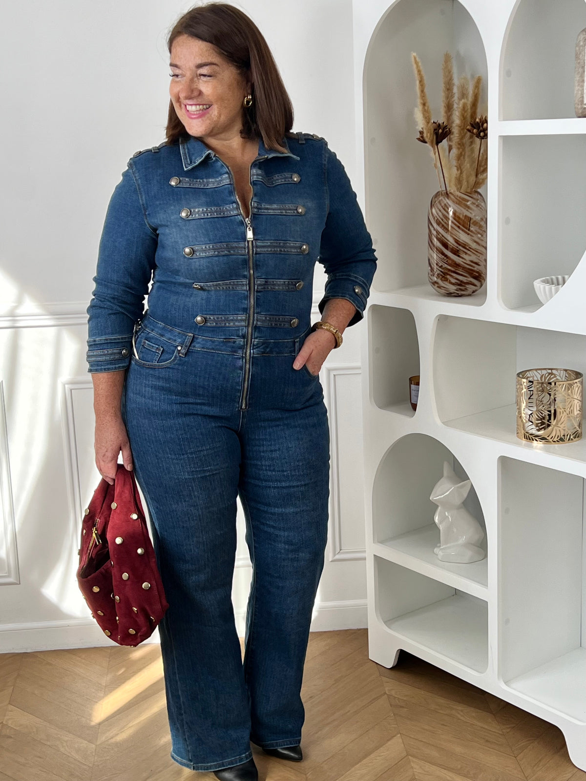 Combinaison en jean bleu grande taille vue de face en pied, montrant sa taille ajustée et ses jambes évasées – Nella | Loïcia