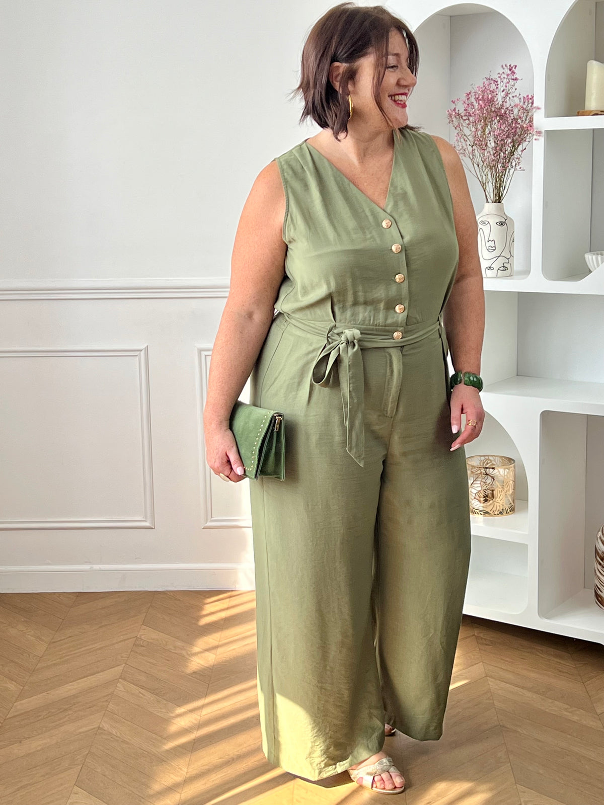 Combinaison longue femme, élégante et moderne, parfaite pour un look tendance au quotidien. Sans manches, avec un col V et des boutons dorés sur le haut, elle apporte une touche chic et raffinée. Dotée d’une ceinture amovible avec passants et d’une taille élastique au dos, elle assure un ajustement confortable. Ses deux poches latérales et sa fermeture zippée à l’avant allient praticité et style.