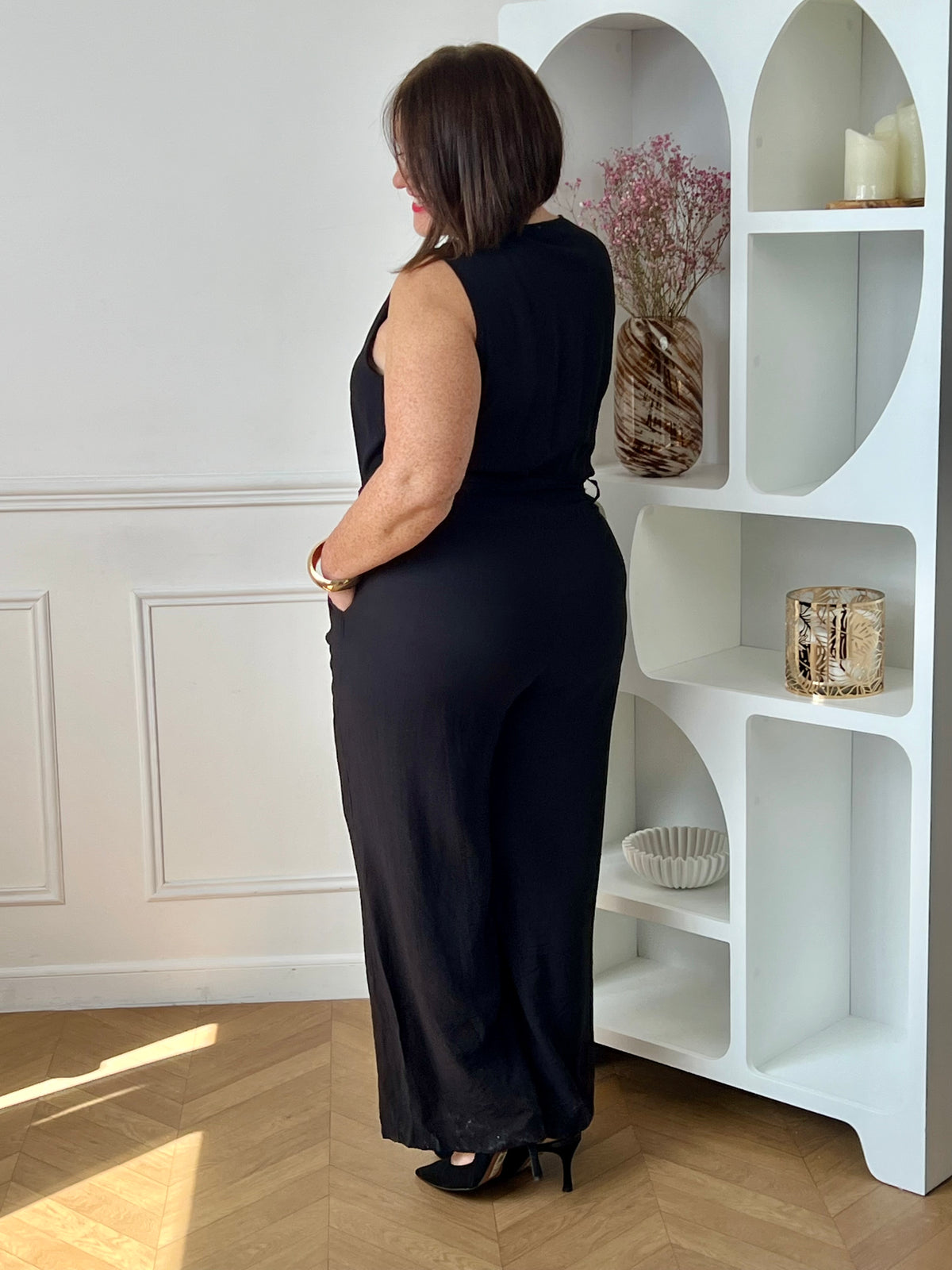 Combinaison longue femme, élégante et moderne, parfaite pour un look tendance au quotidien. Sans manches, avec un col V et des boutons dorés sur le haut, elle apporte une touche chic et raffinée. Dotée d’une ceinture amovible avec passants et d’une taille élastique au dos, elle assure un ajustement confortable. Ses deux poches latérales et sa fermeture zippée à l’avant allient praticité et style.