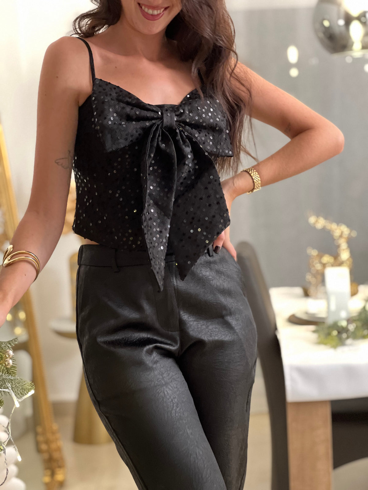 Le top bustier Neela allie style et confort avec ses bretelles réglables et son élégant nœud frontal. Paré de sequins et motifs noirs scintillants, ce bustier noir est votre allié pour des looks glamour et sophistiqués.