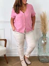 Laissez-vous séduire par notre chemise rose Kira en gaze de coton légère et douce. Avec son col V légèrement festonné et ses boutons dorés le long de la chemise, elle apportera une touche élégante à votre tenue. Profitez du confort et de la fraîcheur du coton 100% naturel pour des journées ensoleillées.