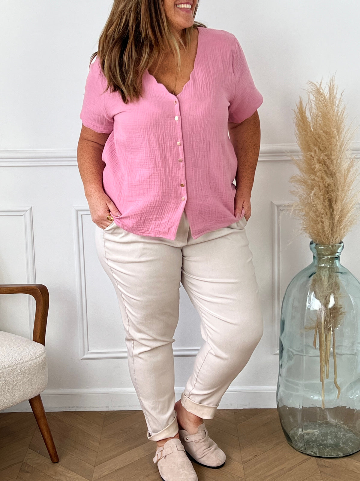 Laissez-vous séduire par notre chemise rose Kira en gaze de coton légère et douce. Avec son col V légèrement festonné et ses boutons dorés le long de la chemise, elle apportera une touche élégante à votre tenue. Profitez du confort et de la fraîcheur du coton 100% naturel pour des journées ensoleillées.