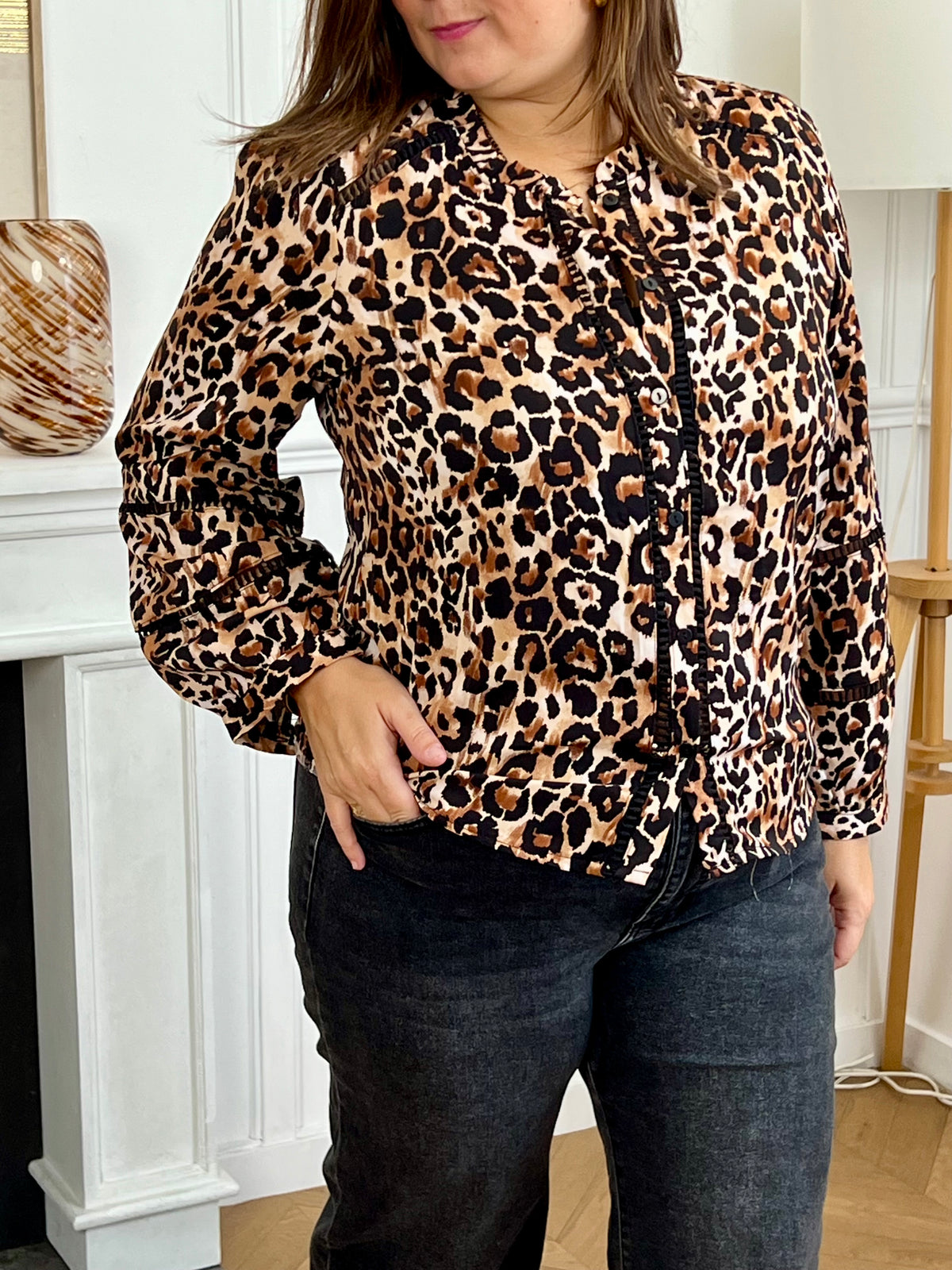 Chemise fluide à motif léopard, ajourée sur le devant et aux manches pour une touche élégante et moderne. Son col montant et ses manches longues lui confèrent une allure chic, idéale pour toutes les occasions. Ses nuances de marron, beige et noir s’accordent facilement pour un style à la fois tendance et raffiné.