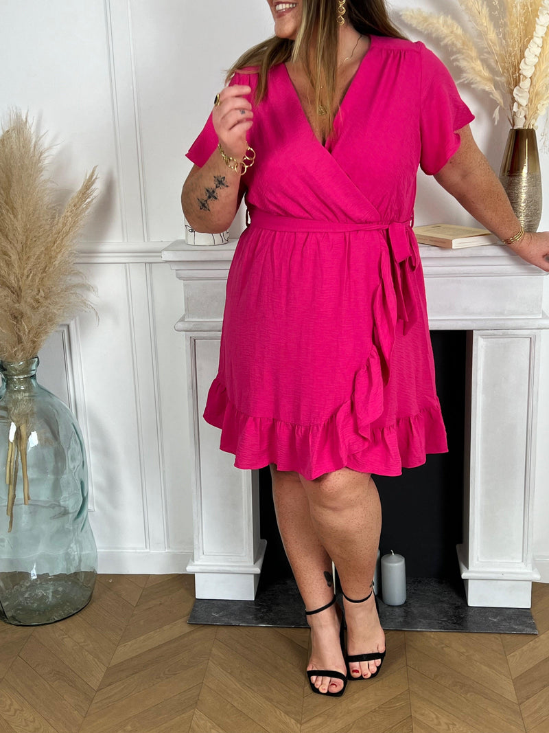 La robe courte fuchsia, sans manches et avec des volants, offre une esthétique féminine et élégante. La couleur rose apporte une touche de féminité, tandis que les volants ajoutent une note ludique à la robe.
