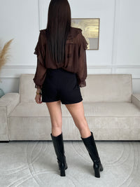 Alliant style et confort, cette jupe-short noire offre une allure chic et moderne. Sa coupe fluide et pratique met en valeur la silhouette tout en assurant une parfaite liberté de mouvement.