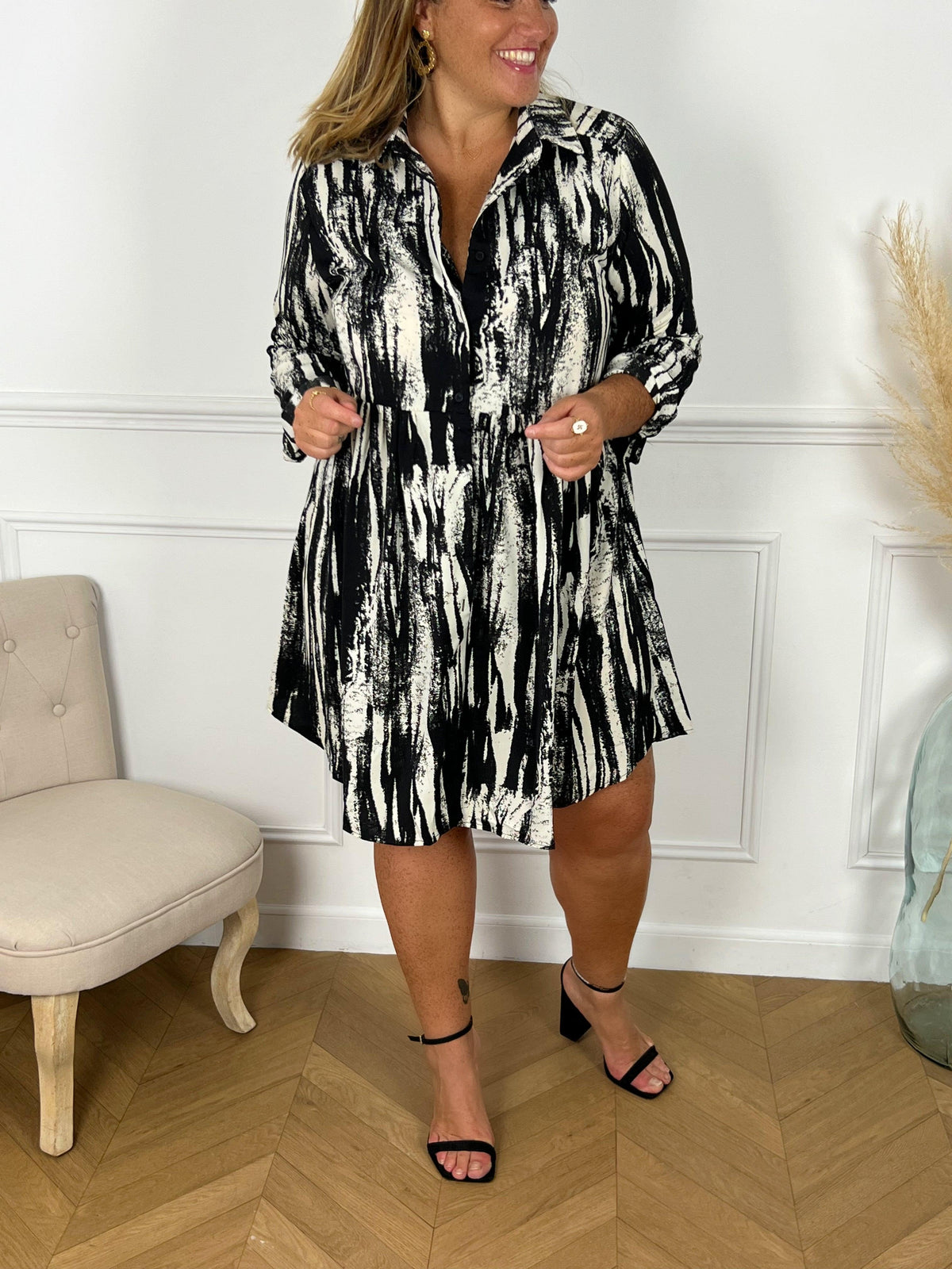 ROBE À MOTIFS GRANDE TAILLE Robe courte à manches longues Col chemise Ample Boutons sur le devant et aux poignets Couleurs : noir et écru Composition: 100% Polyester Lavage à la main obligatoire Made in P.C.R