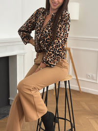 Chemise fluide à motif léopard, ajourée sur le devant et aux manches pour une touche élégante et moderne. Son col montant et ses manches longues lui confèrent une allure chic, idéale pour toutes les occasions. Ses nuances de marron, beige et noir s’accordent facilement pour un style à la fois tendance et raffiné.