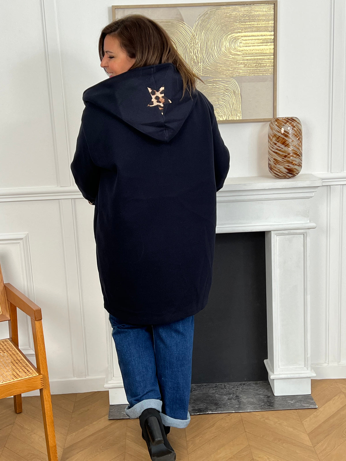 Découvrez notre manteau mi-long bleu marine élégant et tendance, orné de détails léopards sur la capuche et les manches. Pratique et confortable, il dispose de deux poches à l’avant et de boutons sur toute la longueur. Avec sa capuche et son style raffiné, il allie chaleur, originalité et modernité pour un look unique en toute saison.
