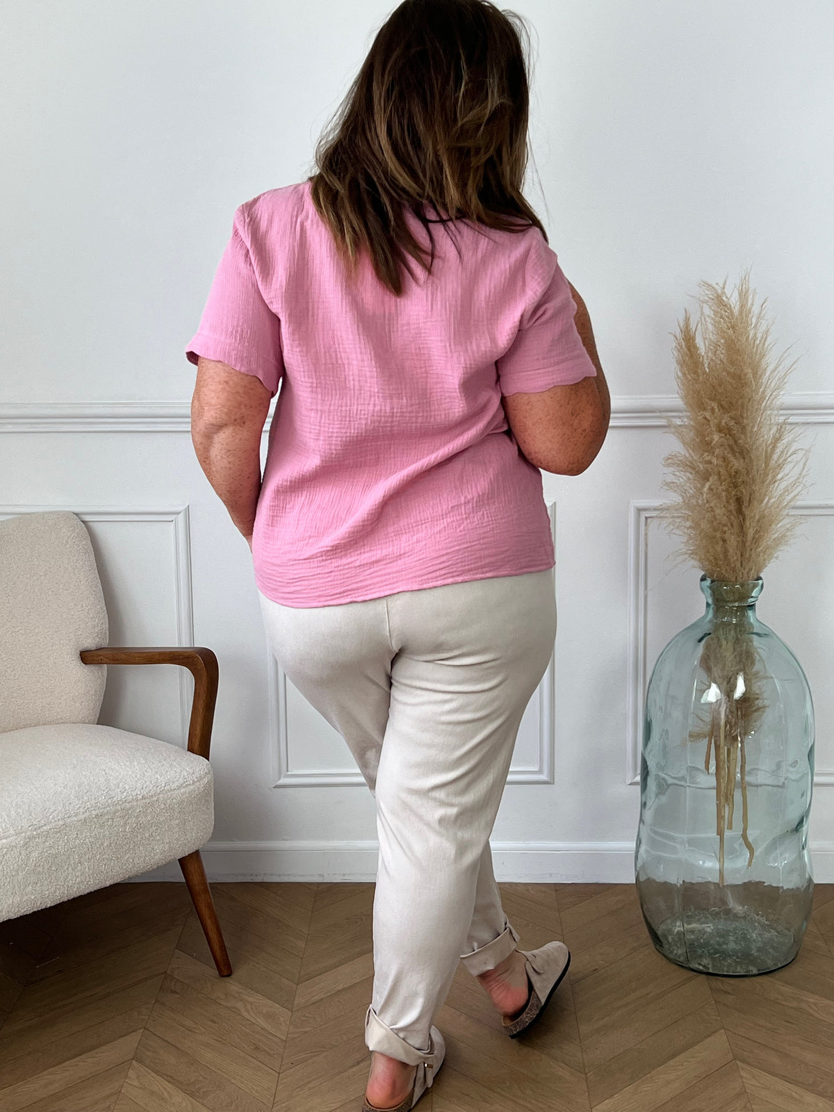 Laissez-vous séduire par notre chemise rose Kira en gaze de coton légère et douce. Avec son col V légèrement festonné et ses boutons dorés le long de la chemise, elle apportera une touche élégante à votre tenue. Profitez du confort et de la fraîcheur du coton 100% naturel pour des journées ensoleillées.