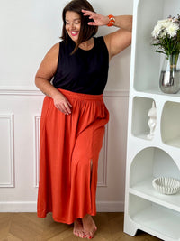Craquez pour cet ensemble blouse et jupe noire grande taille au style élégant et raffiné. La jupe longue à coupe fluide se distingue par sa fente sur le côté, sa tresse à la taille et son élastique au dos pour un confort optimal. La blouse sans manches, dotée d’un col rond avec détail tressé et d’une ouverture au dos avec bouton, apporte une touche féminine et sophistiquée.