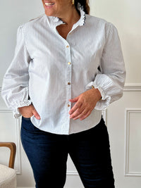 Chemise écrue à rayures bleues grande taille femme, idéale pour un look chic et confortable. Dotée de manches longues, d’un col montant festonné et de boutons dorés sur toute la longueur, elle allie élégance et modernité. Sa coupe fluide avec élastique aux manches assure un confort optimal. Confectionnée en 100 % coton, elle se porte facilement au quotidien.