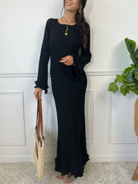 La robe longue noir Esther est un mariage parfait de chic et de confort. Avec ses manches longues et son col rond, elle assure une élégance intemporelle. Mais le dos nu avec lacets croisés et les volants aux manches et au bas de la robe ajoutent une touche ludique et originale. Soyez prête à faire tourner les têtes avec cette robe unique !