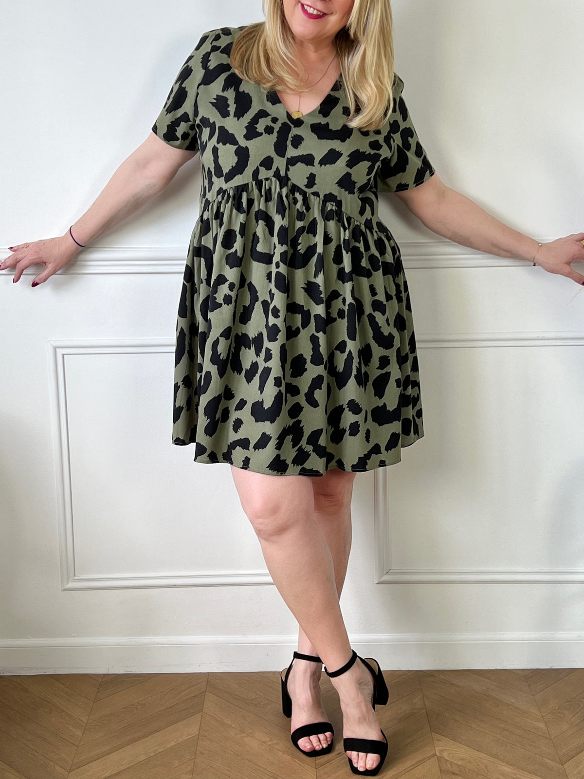 Offrez-vous un look frais et élégant avec notre robe courte kaki à motif Romie. Avec sa coupe ample et ses motifs noirs, elle vous donnera un style unique et confortable. Parfaite pour toutes les occasions, cette robe est un must-have pour votre garde-robe!