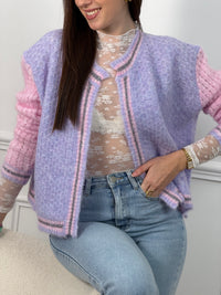 Découvrez le Gilet Nadège, une pièce incontournable alliant style et confort. Ce gilet en laine violet arbore des manches longues roses qui créent un contraste harmonieux et moderne. Son col rond épuré se complète par des bords délicatement ornés de fils colorés brillants, apportant une touche d'éclat à votre silhouette.&nbsp;