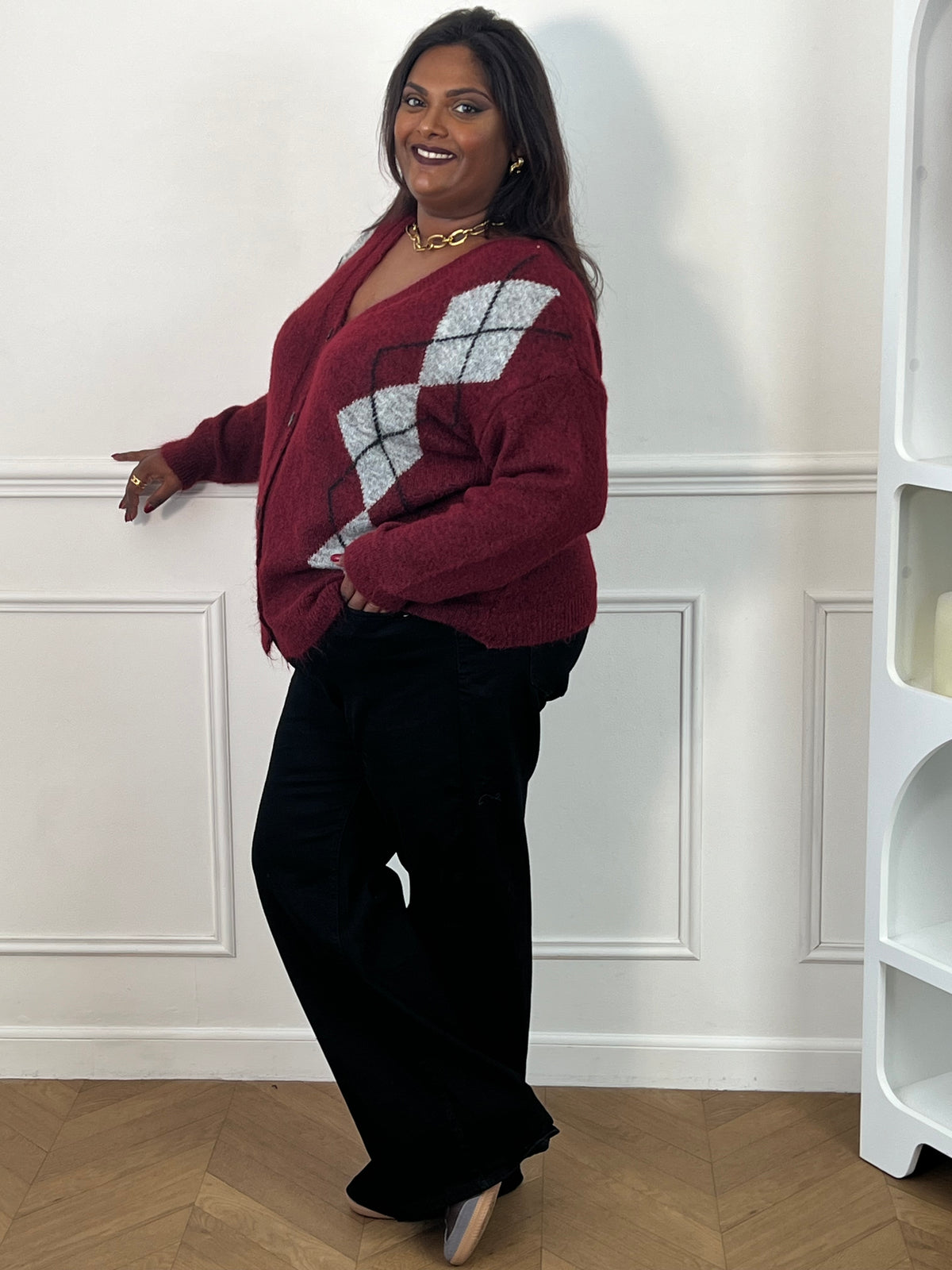 Gilet bordeaux grande taille vu de trois quarts, montrant les motifs à losanges sur le côté et sa longueur sur les hanches – Isadora | Loïcia