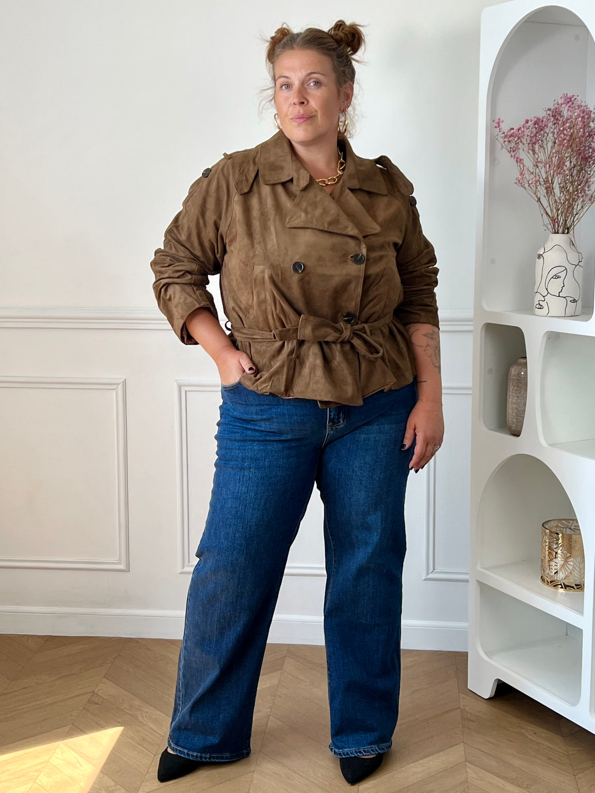 Jean bleu wide leg grande taille femme porté avec une veste marron, pour un look tendance et décontracté.