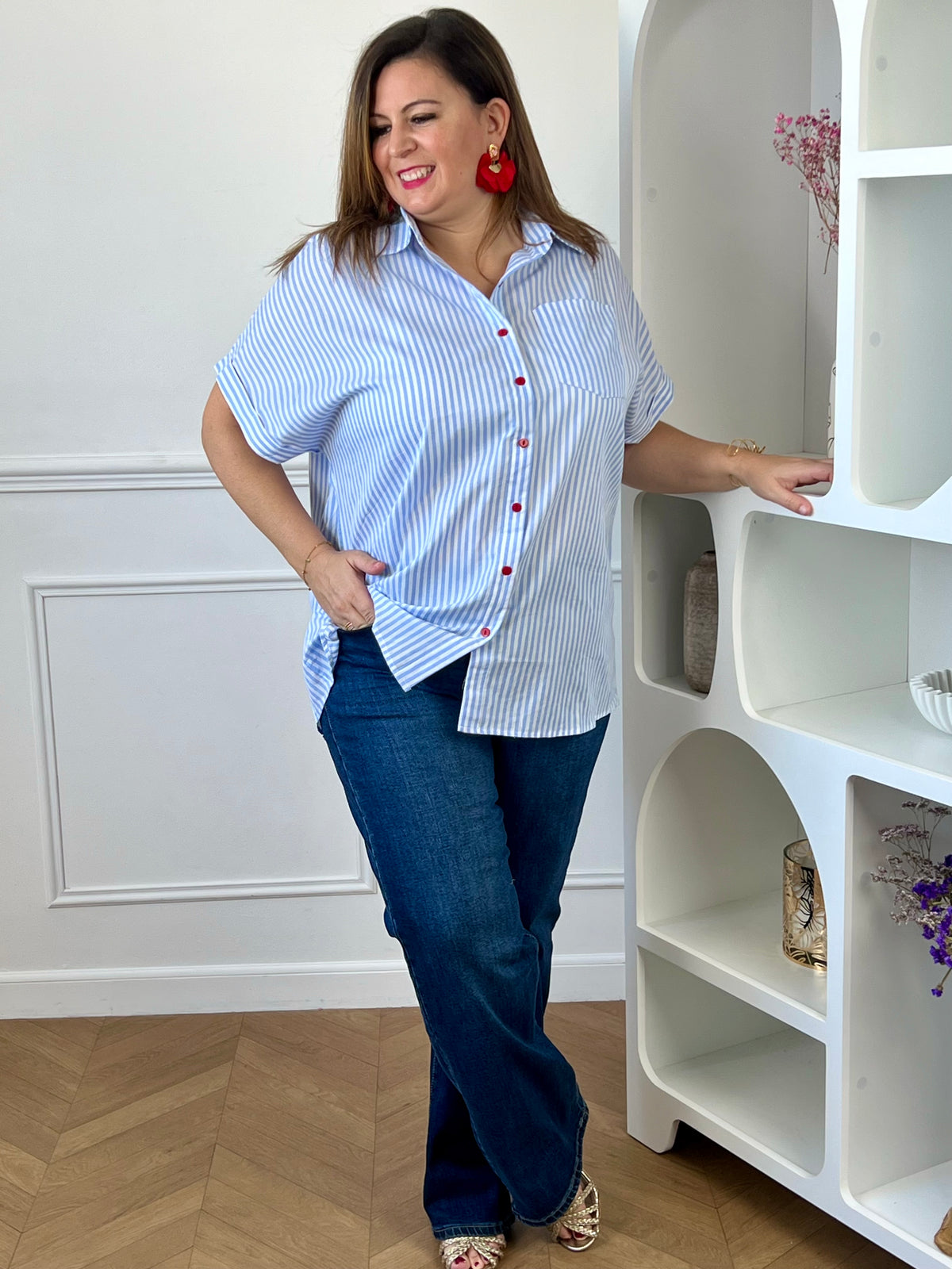 Jean bleu grande taille femme associé à une chemise bleu ciel pour une tenue moderne et élégante.