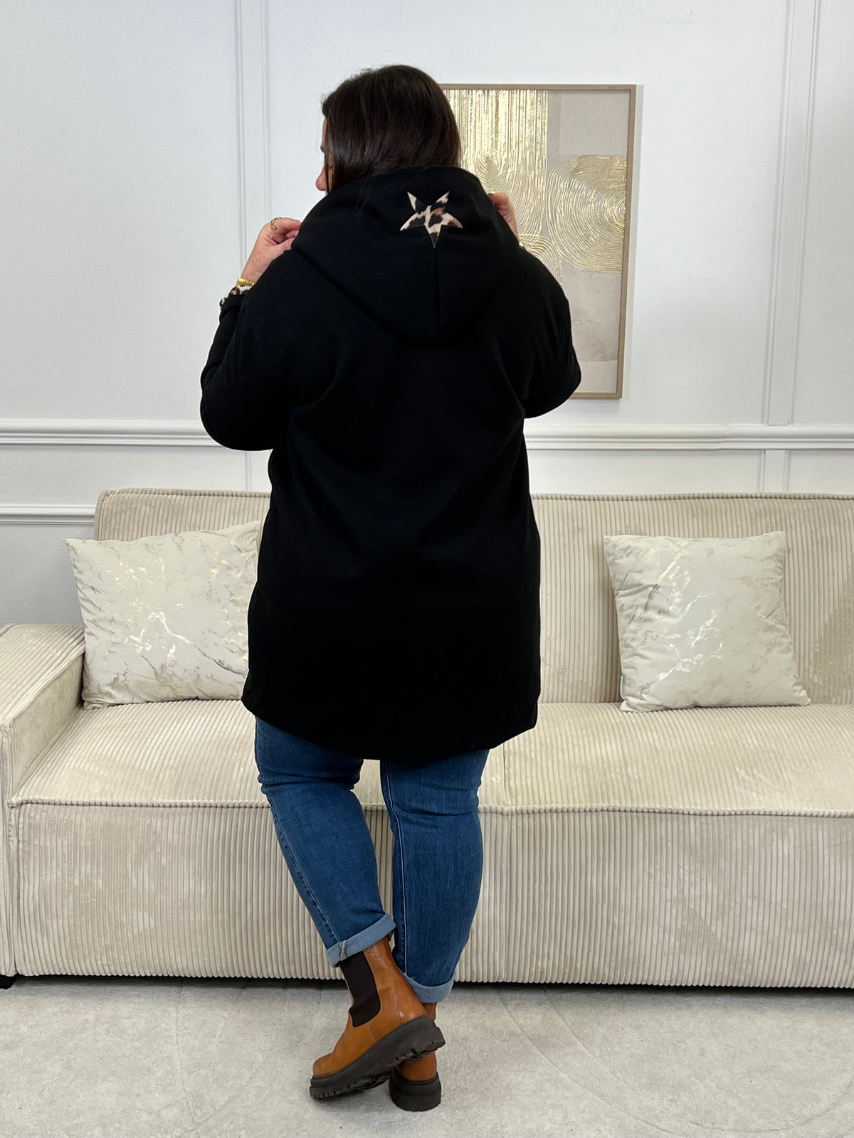 Découvrez notre manteau mi-long noir élégant et tendance, orné de détails léopards sur la capuche et les manches. Pratique et confortable, il dispose de deux poches à l’avant et de boutons sur toute la longueur. Avec sa capuche et son style raffiné, il allie chaleur, originalité et modernité pour un look unique en toute saison.