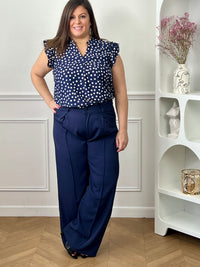 Pantalon grande taille femme à coupe droite, parfait pour une silhouette élégante et confortable. Doté de plis sur le devant et d’une taille élastique au dos, il assure un ajustement optimal tout en restant agréable à porter. Ses passants pour ceinture permettent de structurer la tenue selon vos envies. Confectionné dans une matière fluide, ce pantalon bleu marine est idéal pour un look chic et polyvalent au quotidien.