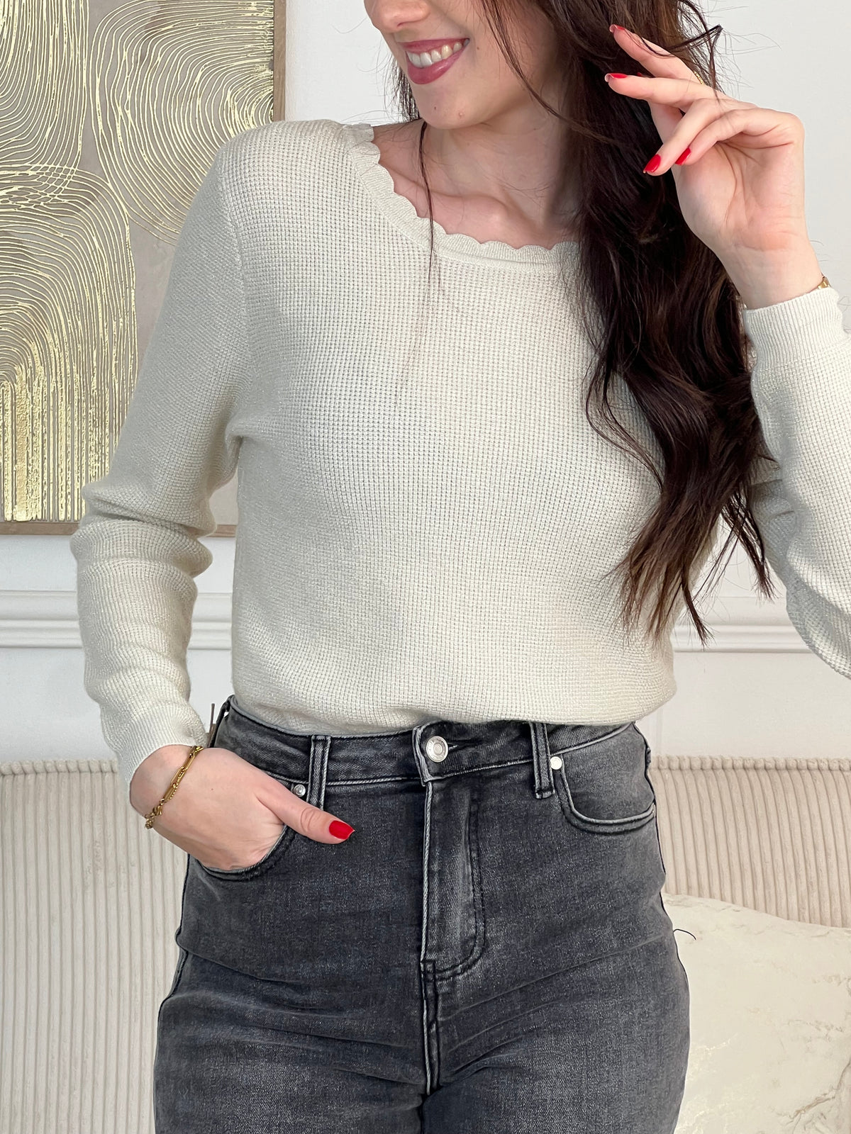 Le pull Celestina combine élégance et sensualité avec son dos nu en V à lien noué et ses manches longues. Orné de fil lurex doré, ce pull beige et doré brille de mille feux. Son col rond festonné ajoute une touche de raffinement pour des occasions spéciales.