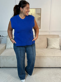 Ophelia, le pull sans manches bleu roi pour femme grande taille qui transforme votre garde-robe. Son col rond épuré et ses boutons marrons latéraux lui confèrent une touche de caractère. Versatile et incontournable, portez-le seul pour un look minimaliste ou superposez-le sur une chemise ou un top pour créer des combinaisons sans fin.