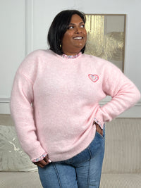 Confectionné en grande taille, ce pull rose séduira par son élégance intemporelle. Ses manches longues et son col V flatteront votre silhouette, tandis que les motifs floraux délicats ornant le col et les poignets ajoutent une touche de féminité. Le cœur brodé sur le devant, agrémenté de motifs floraux assortis, crée un détail charmant et personnel.&nbsp;