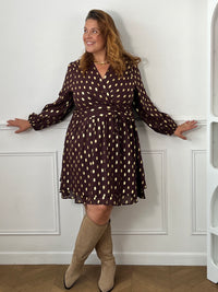 Robe courte Faustina portée de face avec des bottes beiges, montrant la taille ceinturée et la jupe évasée à pans superposés.