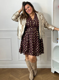 Robe marron Faustina à pois dorés portée sous une veste dorée, avec des bottes beiges.