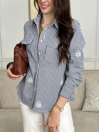 Découvrez la surchemise Anabelle, une pièce incontournable pour un style décontracté et élégant. Confectionnée en coton, elle arbore des rayures verticales subtiles dans les tons écru et bleu. Son col chemise classique et ses manches longues offrent une allure intemporelle, tandis que les motifs brodés délicats sur le devant et les manches ajoutent une touche de caractère.