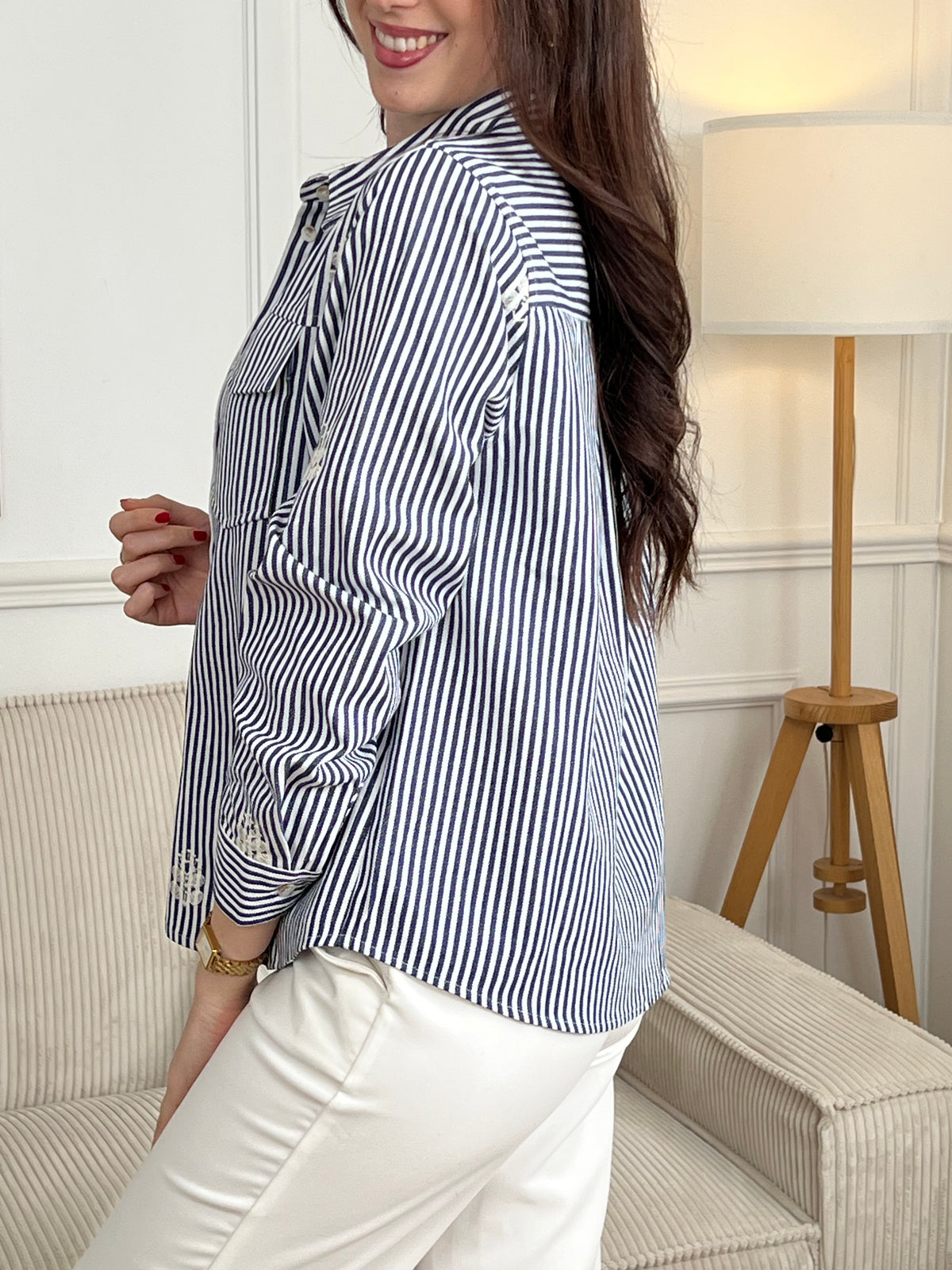 Découvrez la surchemise Anabelle, une pièce incontournable pour un style décontracté et élégant. Confectionnée en coton, elle arbore des rayures verticales subtiles dans les tons écru et bleu. Son col chemise classique et ses manches longues offrent une allure intemporelle, tandis que les motifs brodés délicats sur le devant et les manches ajoutent une touche de caractère.