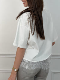 Découvrez notre tee-shirt blanc Romeo, un incontournable de la garde-robe féminine. Coupe épurée avec manches courtes et col rond, il allie confort et élégance. La dentelle délicate qui orne le bas ajoute une touche de féminité raffinée à ce basique polyvalent. Parfait pour créer des looks simples et sophistiqués au quotidien.