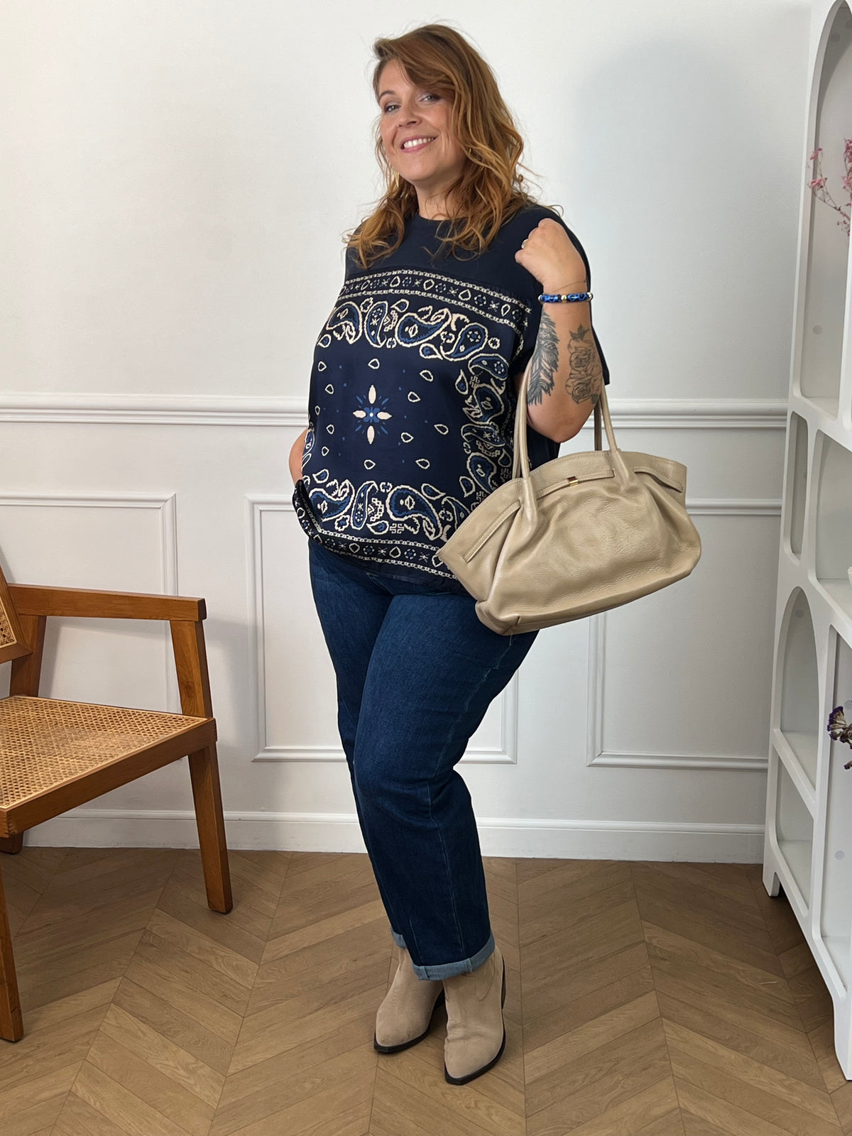Tee-shirt bleu Livana porté avec un jean retroussé, des bottines beiges et un grand sac beige, vue en pied.