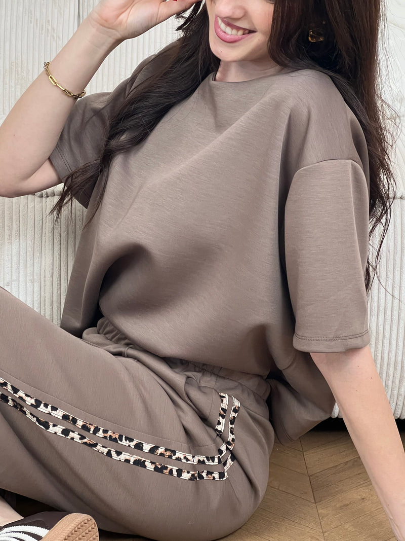 Notre tee-shirt Nilo en taupe est le basique indispensable pour construire une garde-robe sans effort. Réalisé dans une matière épaisse qui assure confort et tenue, il propose une coupe généreuse qui met en valeur chaque silhouette. Avec ses manches courtes et son col rond intemporel, ce top s'associe facilement à tous vos essentiels, notamment au jogging Nilo pour un look coordonné et décontracté.