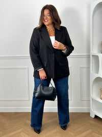 Top blanc col carré grande taille porté avec un blazer noir oversize, jean wide leg bleu et sac bowling noir - look chic et élégant