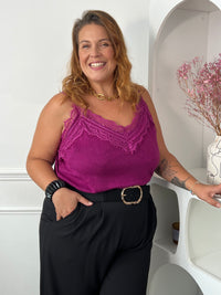 Top magenta à fines bretelles et décolleté en V bordé de dentelle, rentré dans un pantalon noir ceinturé – Maelie | Loïcia