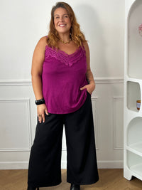 Top magenta à dentelle porté de face sur un pantalon large noir, montrant sa coupe fluide et sa longueur sur les hanches – Maelie | Loïcia