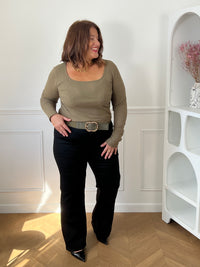 Top kaki Alix porté de face avec un pantalon noir et une ceinture kaki à boucle dorée, vue en pied.