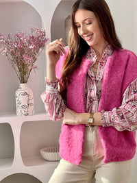 Adoptez cette veste sans manches femme, simple et tendance. Dotée d’un col rond, elle est idéale pour superposer vos tenues avec style. Sa couleur rose apporte une touche douce et féminine à votre look.