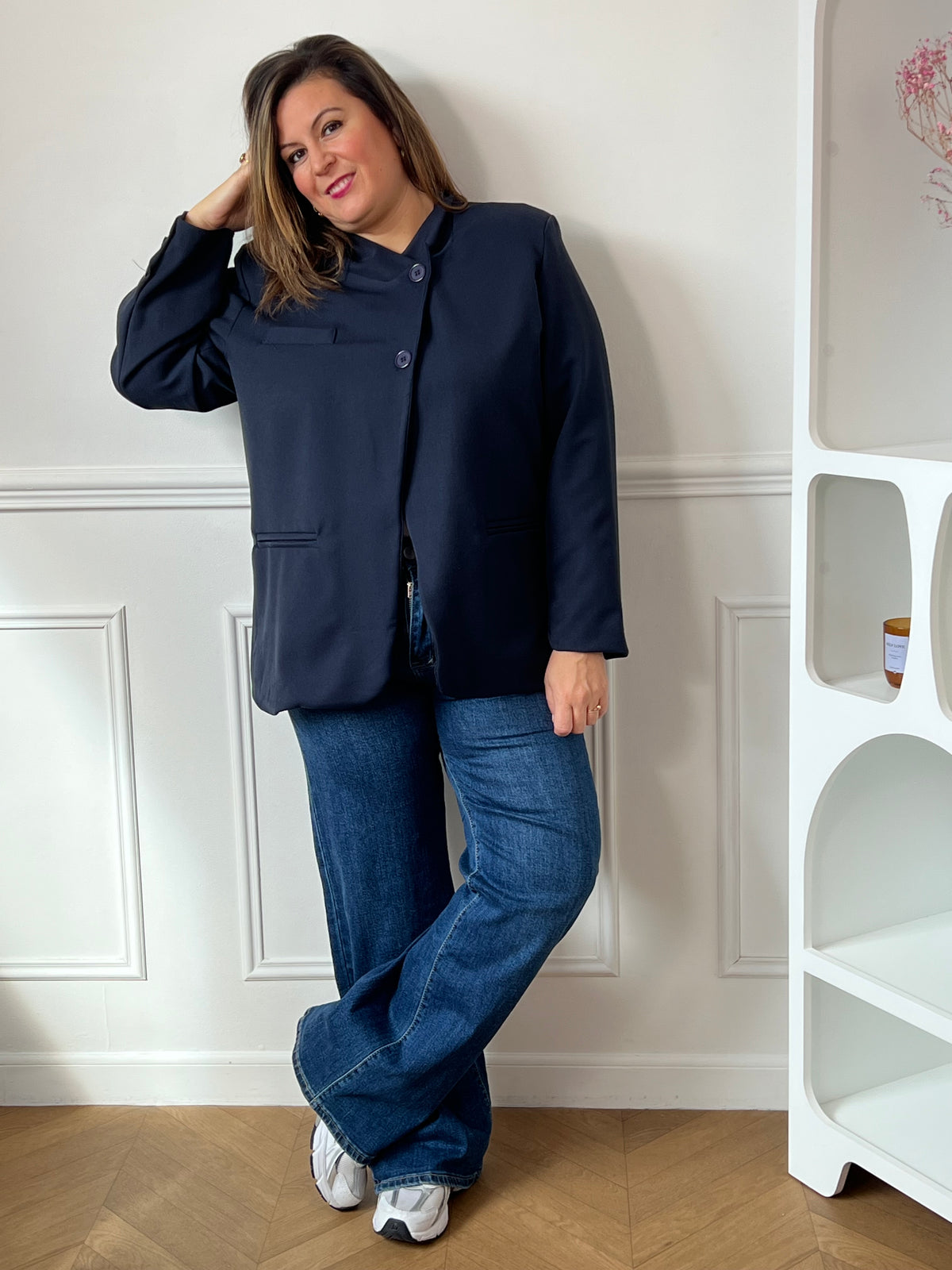 Veste bleu marine Loen grande taille portée fermée avec un jean bleu et des baskets, vue de face en pied.