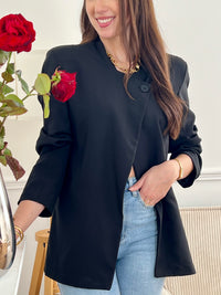 Optez pour cette veste noire femme au style moderne et structuré. Sa coupe asymétrique croisée sur le devant lui apporte une allure élégante et originale. Dotée de manches longues, d’un col montant et d’un bouton sur le haut, elle est doublée pour plus de confort. Une veste noire chic, idéale pour compléter vos tenues.