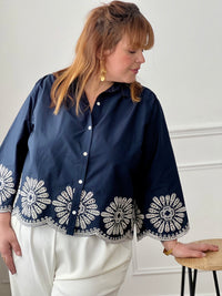 Chemise bleue en coton grande taille, idéale pour un look à la fois élégant et confortable. Dotée de boutons sur toute la longueur et aux manches, elle allie praticité et style. Ses détails de broderie blanche ajourée apportent une touche raffinée et féminine. Confectionnée en 100% coton, elle offre douceur et respirabilité pour un porté agréable au quotidien.
