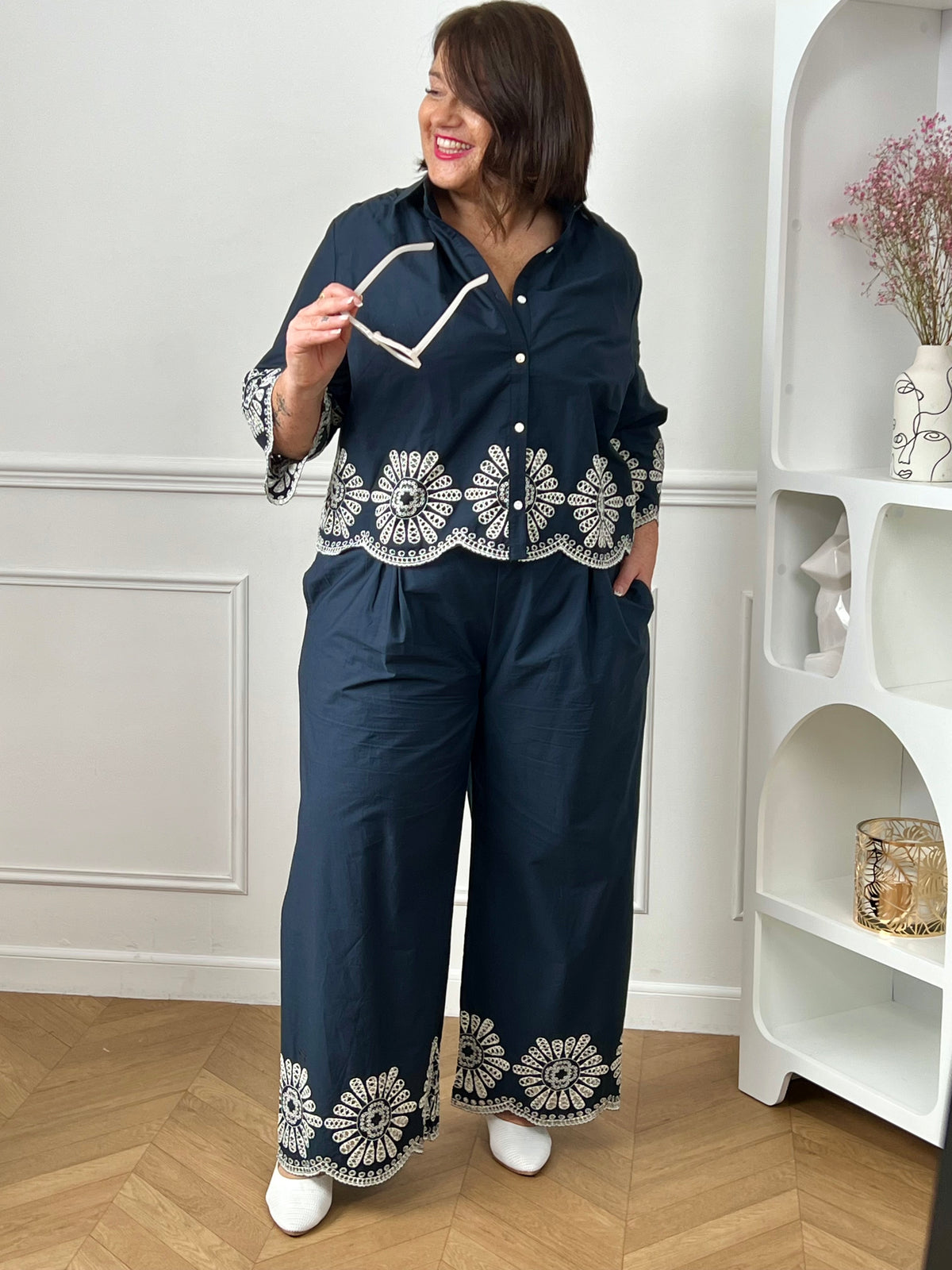 Chemise bleue en coton grande taille, idéale pour un look à la fois élégant et confortable. Dotée de boutons sur toute la longueur et aux manches, elle allie praticité et style. Ses détails de broderie blanche ajourée apportent une touche raffinée et féminine. Confectionnée en 100% coton, elle offre douceur et respirabilité pour un porté agréable au quotidien.