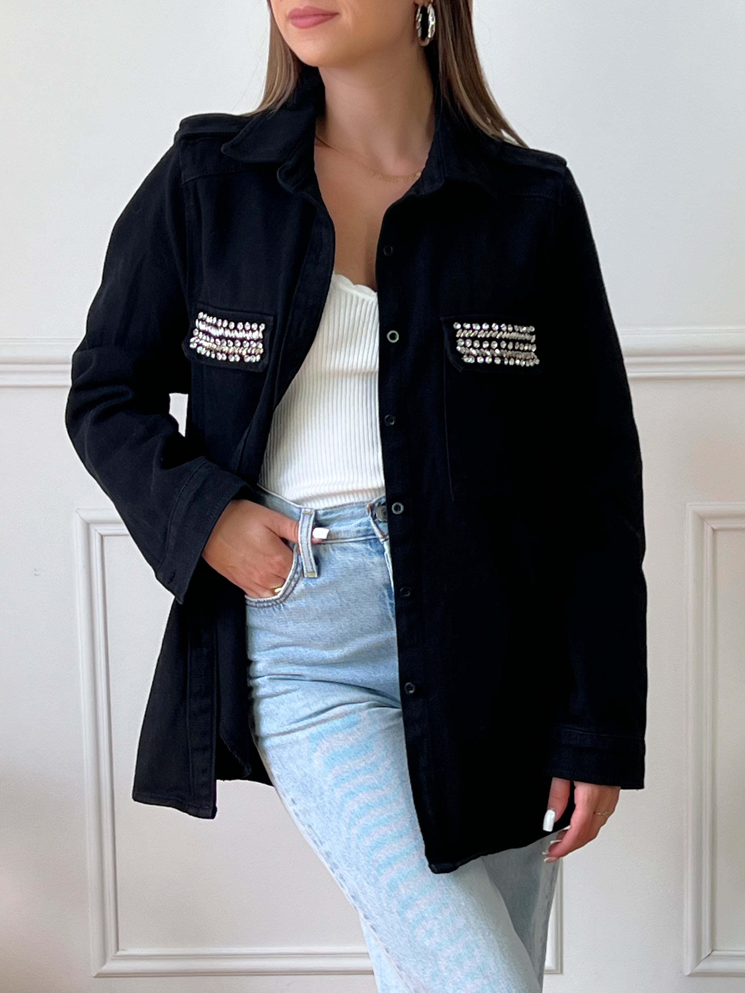 VESTE NOIRE EN COTON FEMME Veste manches longues Boutons sur la longueur et aux poignets 2 poches au niveau de la poitrine et 2 poches latérales à découdre Strass sur les poches à la poitrine Couleur : noir Composition : 100% Coton