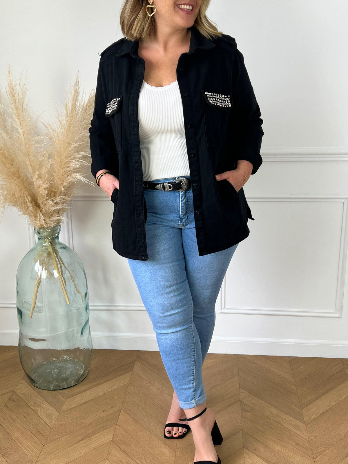 VESTE NOIRE EN COTON FEMME GRANDE TAILLE Veste manches longues Boutons sur la longueur et aux poignets 2 poches au niveau de la poitrine et 2 poches latérales à découdre Strass sur les poches à la poitrine Couleur : noir Composition : 100% Coton