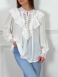 BLOUSE BLANCHE AVEC BRODERIE ET VOLANTS Chemise manches longues Ajourée au niveau du décolleté Broderie au col et aux manches Volants sur la poitrine et haut du dos Légèrement transparente Boutons blancs jusqu'à mi longueur et aux poignets Couleur : écru Composition : 100% Coton Lavage à la main recommandé