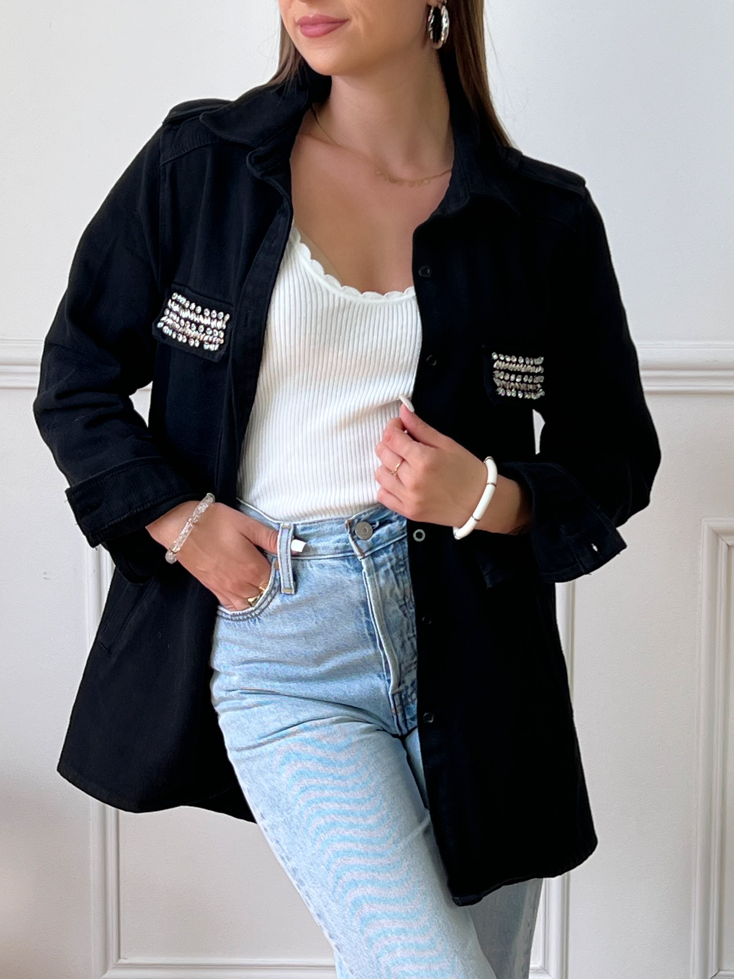 VESTE NOIRE EN COTON FEMME Veste manches longues Boutons sur la longueur et aux poignets 2 poches au niveau de la poitrine et 2 poches latérales à découdre Strass sur les poches à la poitrine Couleur : noir Composition : 100% Coton